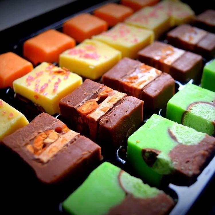 A colourful selection of chocolate fudge topped with nuts, chocolate and sweet treats