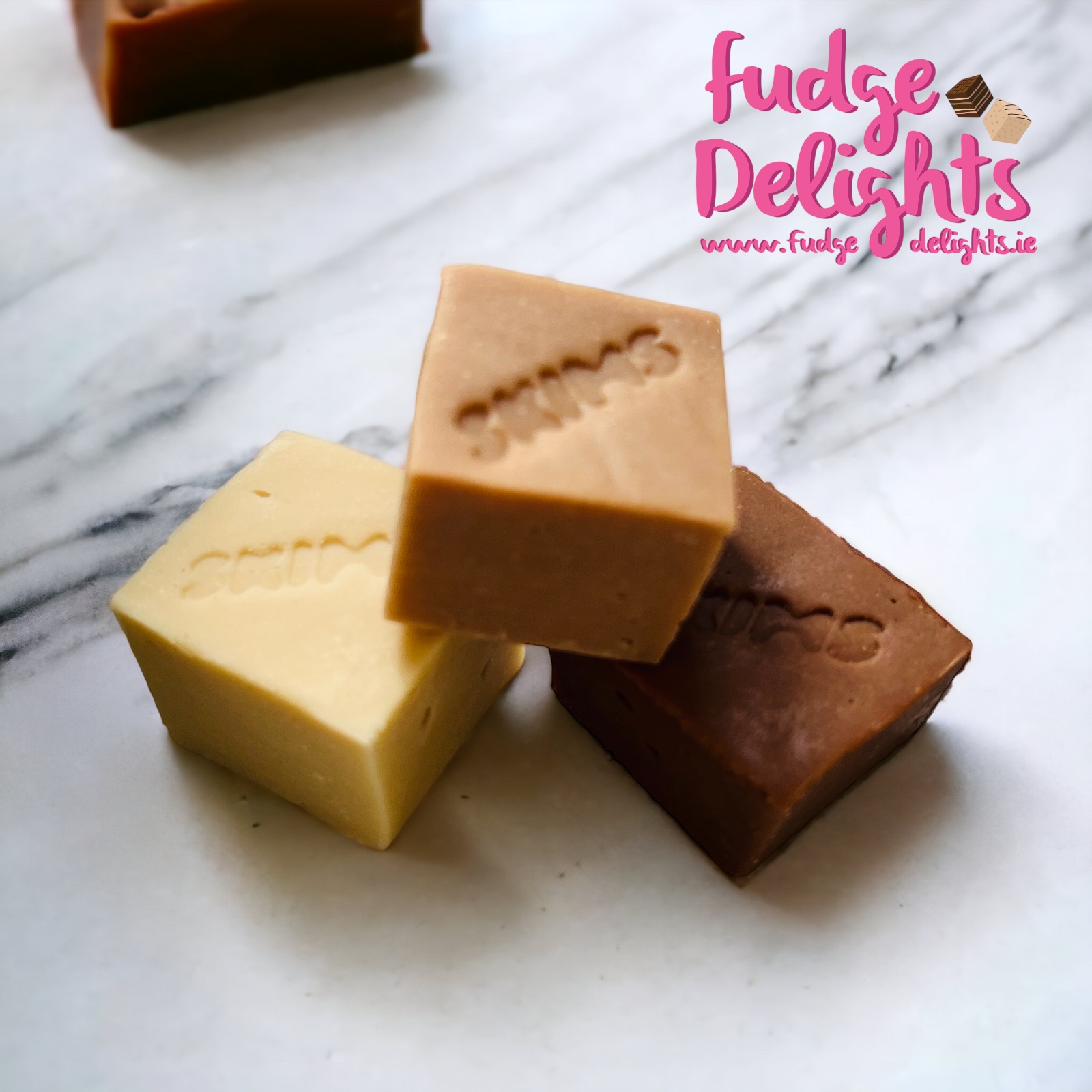 Three pieces of Fudge Delights fudge in chocolate and golden caramel colours